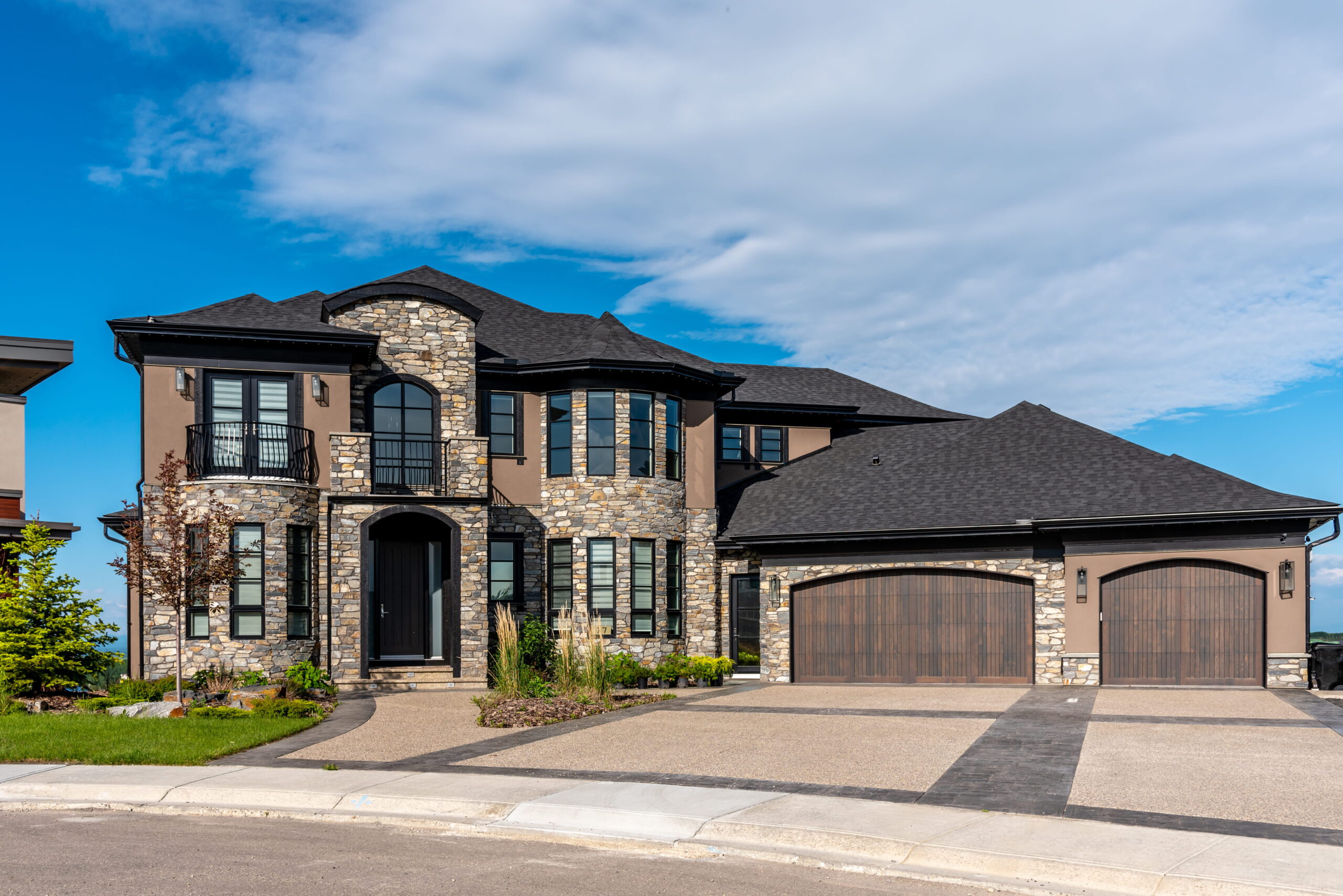 Custom built luxury home in Ontario featuring stone exterior, triple garage, and professional landscaping