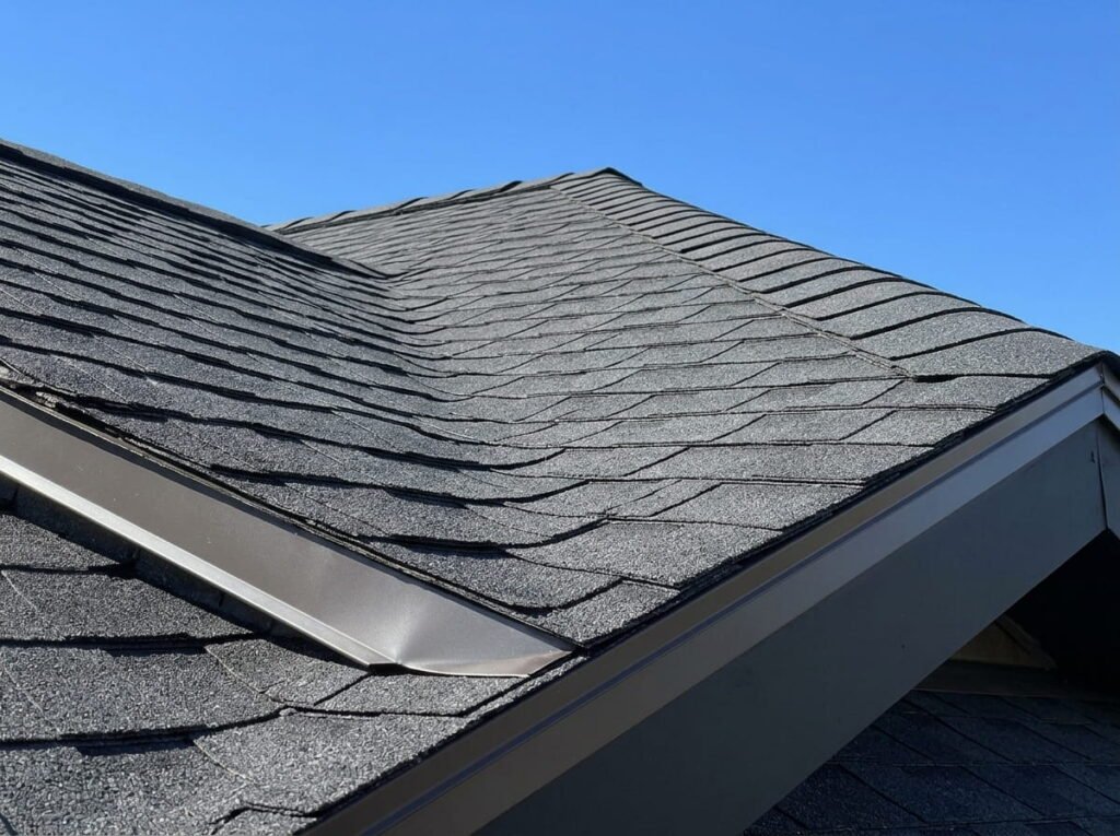 Newly installed architectural asphalt shingle roof with ridge cap and drip edge