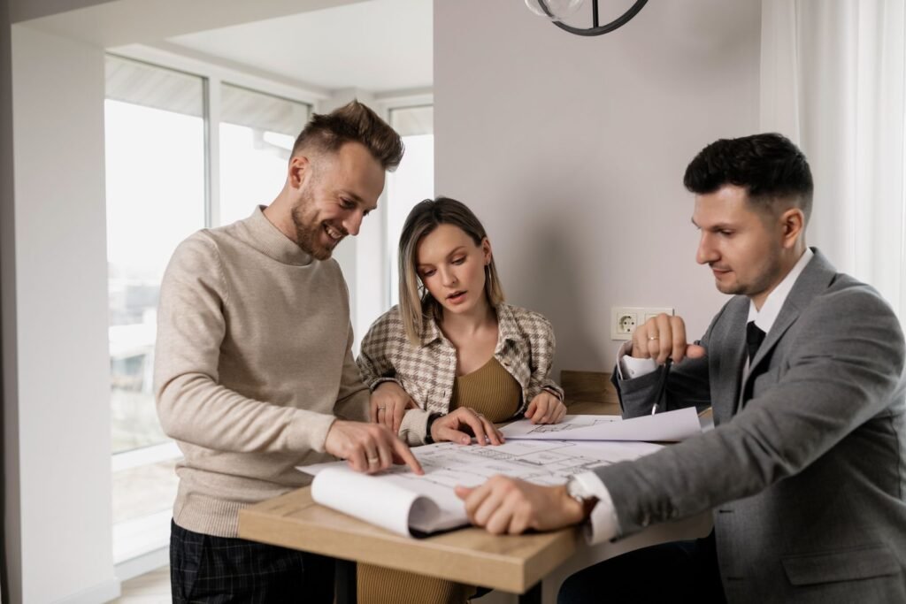 Homeowners reviewing house plans with a professional before a minor variance application