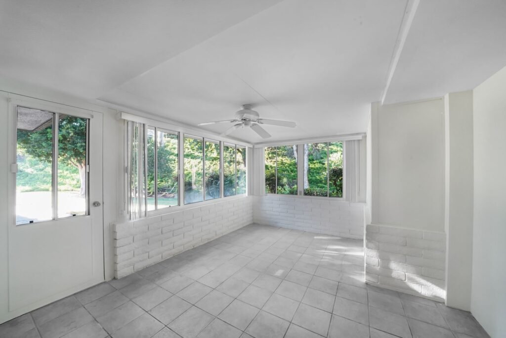 Bright four-season sunroom addition with tiled floor and large windows