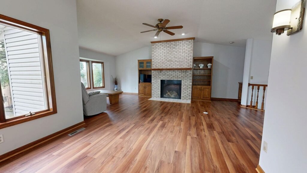 Renovated living room with wood floors and brick fireplace