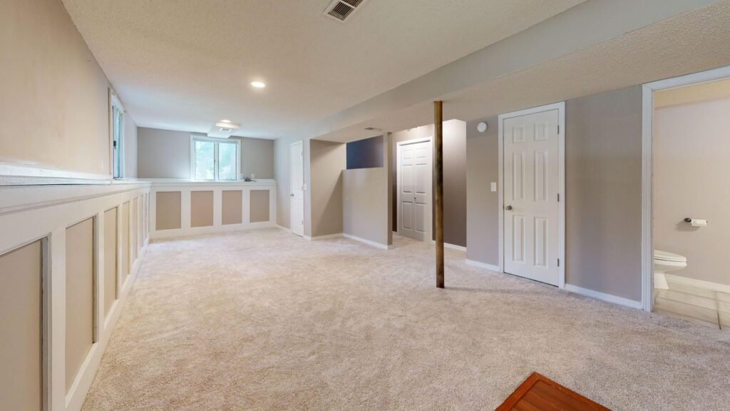 Bright finished basement with recessed lighting and new flooring