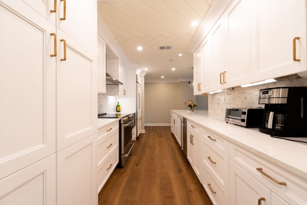 Bright renovated kitchen with white cabinets and wood floor