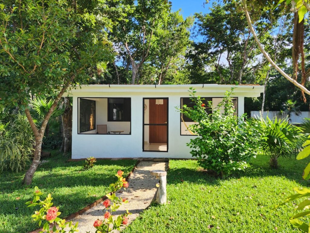 Small detached backyard suite surrounded by garden greenery